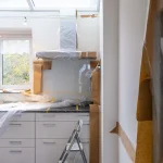 Kök under renovering med skåp skyddade av plastfolie