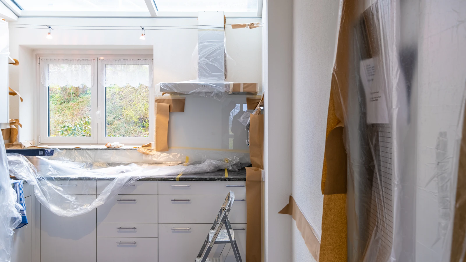 Kök under renovering med skåp skyddade av plastfolie
