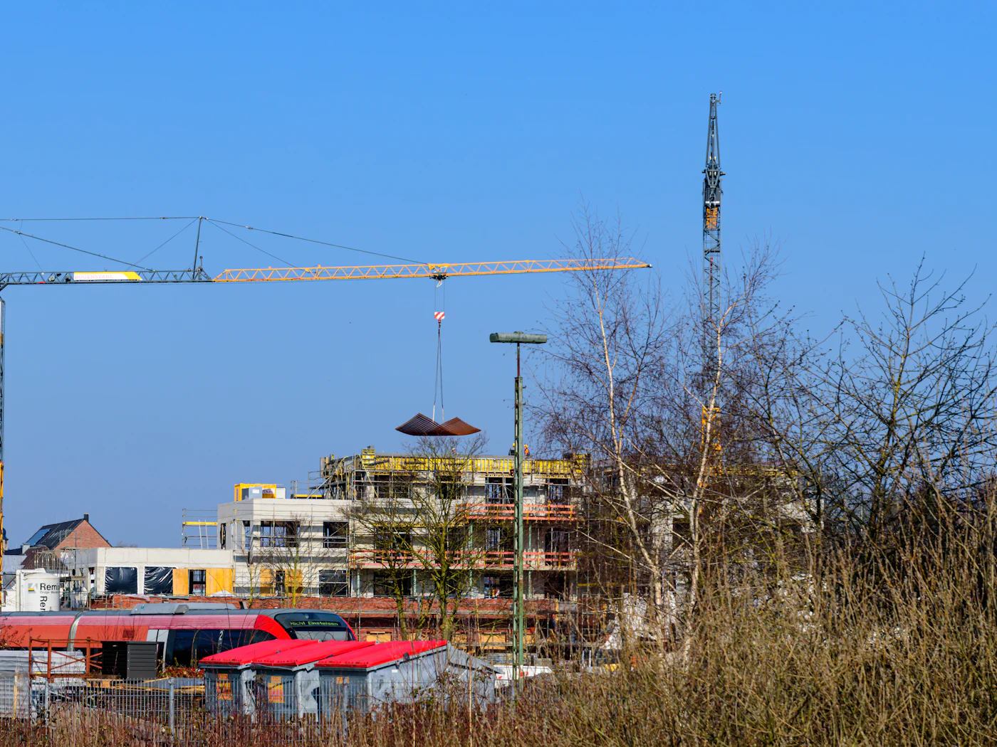 Byggarbetsplats med tornkranar och nya flerbostadshus under uppförande